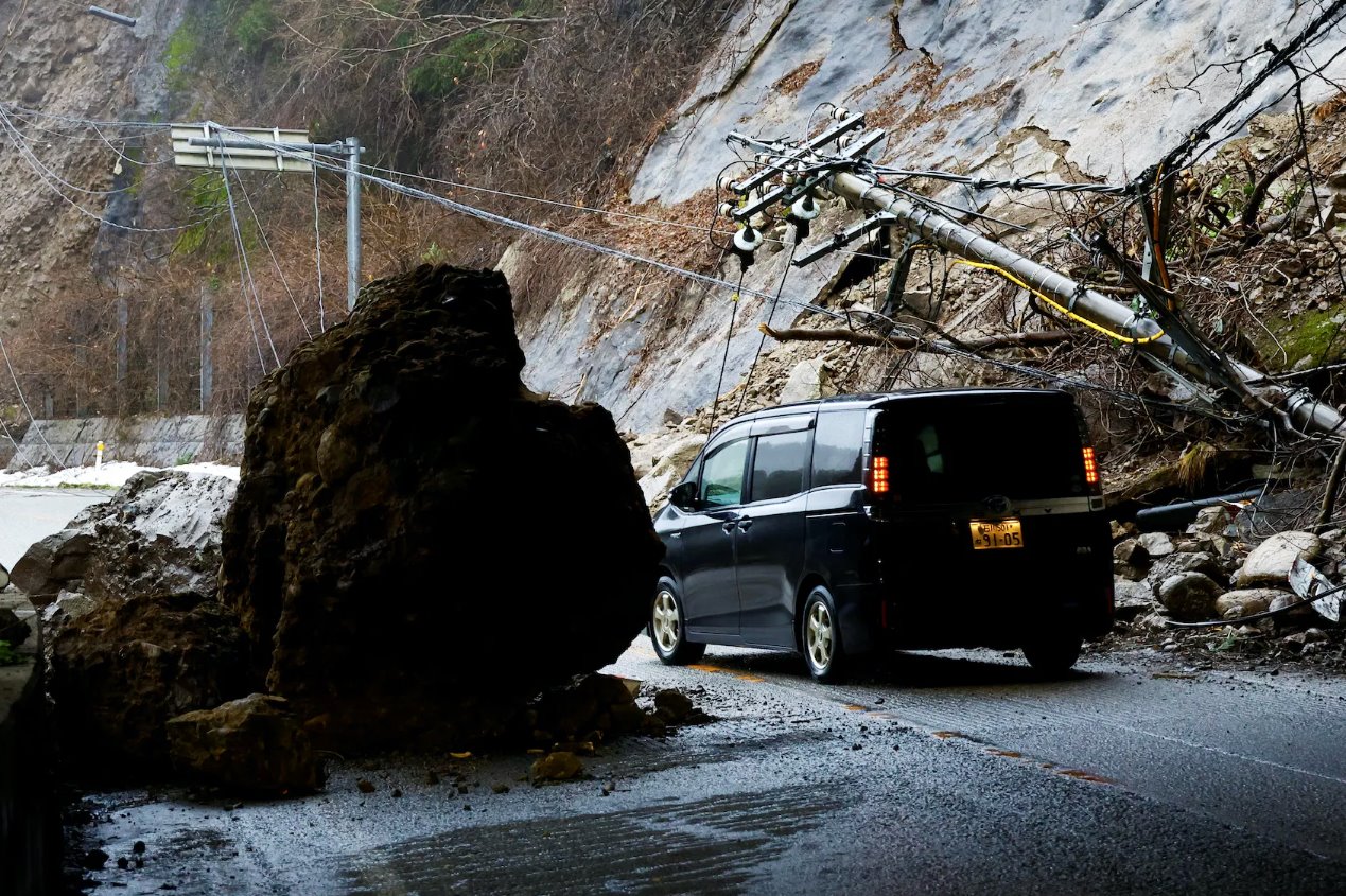 2024年1月3日，日本輪島，地震后，一輛汽車在受損的道路上行駛。