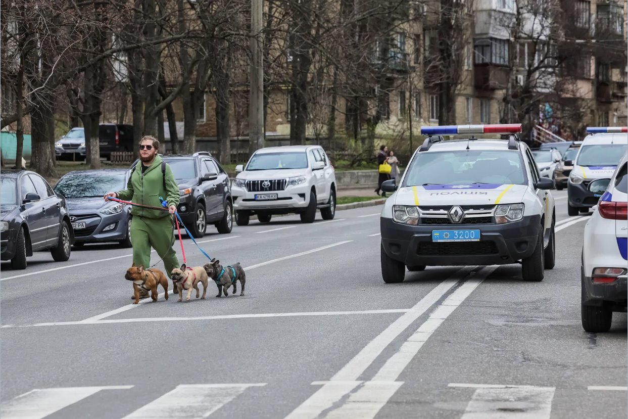 2024年3月25日，烏克蘭基輔，在俄羅斯襲擊烏克蘭期間，一名當(dāng)?shù)鼐用駧е墓吩诙砹_斯導(dǎo)彈襲擊地點(diǎn)附近散步。