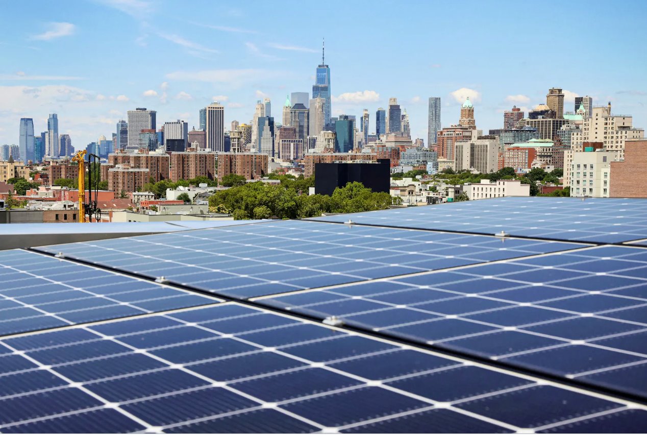 2022年8月16日，在美國紐約布魯克林公園坡社區(qū)，從該市第一座大型木結(jié)構(gòu)公寓樓TimberHouse的屋頂上可以看到太陽能電池板以及附近地區(qū)和曼哈頓下城的景色。