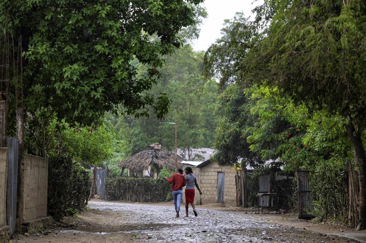 2024年4月27日，海地自由堡馬爾費(fèi)蒂社區(qū)，婦女在雨中行走。