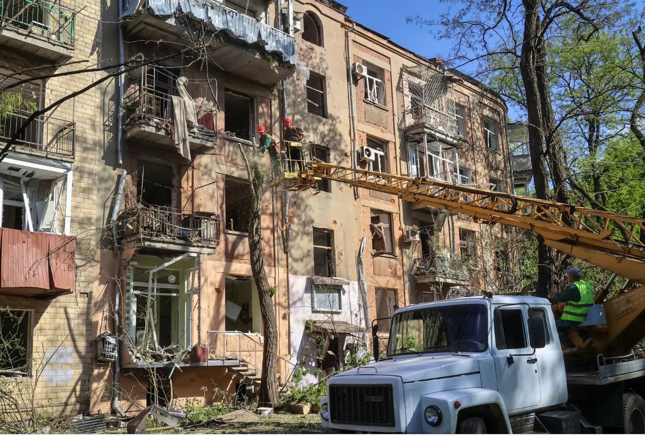 2024年5月5日，烏克蘭哈爾科夫，社區(qū)工作人員在烏克蘭哈爾科夫一棟因俄羅斯空襲而受損的公寓樓附近的工地工作。