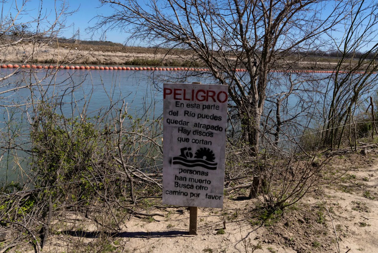 2024年2月25日，墨西哥科阿韋拉州彼德拉斯內(nèi)格拉斯，一塊標(biāo)志警告移民試圖通過格蘭德河上的漂浮屏障進(jìn)入美國將面臨極大危險。