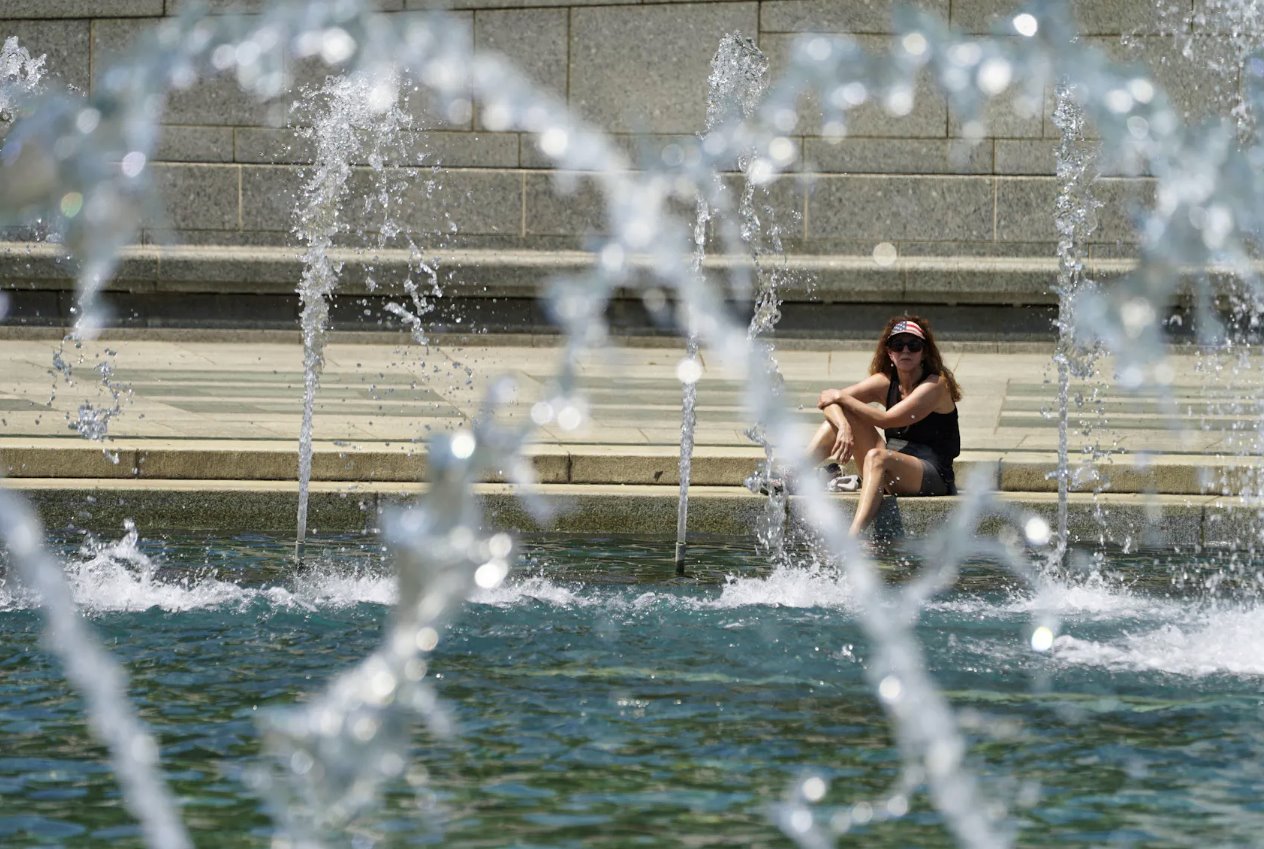 2024年4月29日，美國(guó)華盛頓，在可能創(chuàng)紀(jì)錄的高溫日，一名戴著星條旗遮陽(yáng)帽的女士將腳浸入二戰(zhàn)紀(jì)念館的涼爽噴泉中。