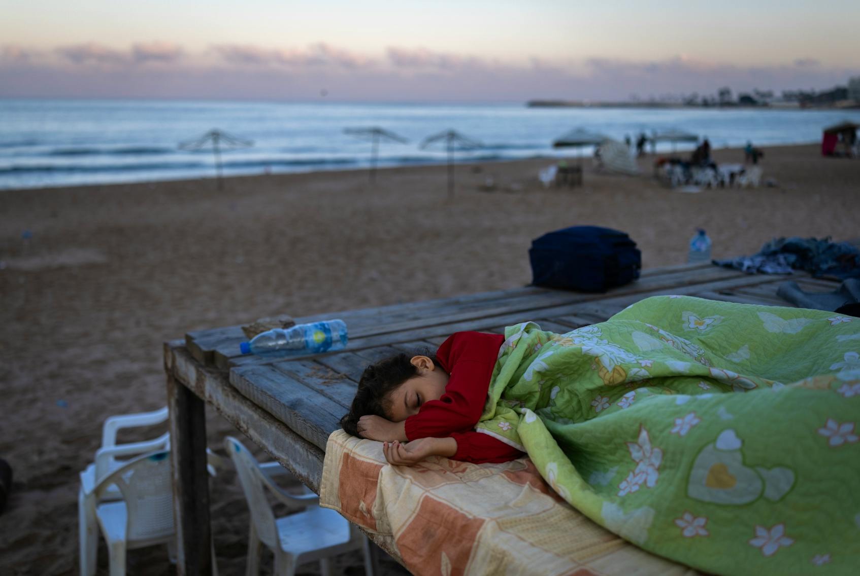 2024年9月29日，黎巴嫩貝魯特，一名男孩和家人逃離空襲，在貝魯特的RamletAlBaida海灘避難。
