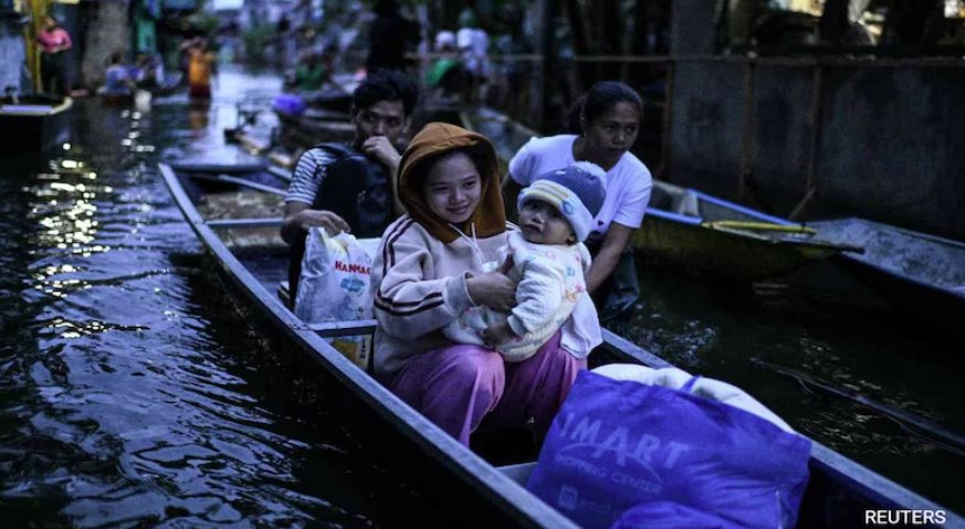 菲律賓熱帶風(fēng)暴博羅依加劇降雨，民眾乘船過馬路
